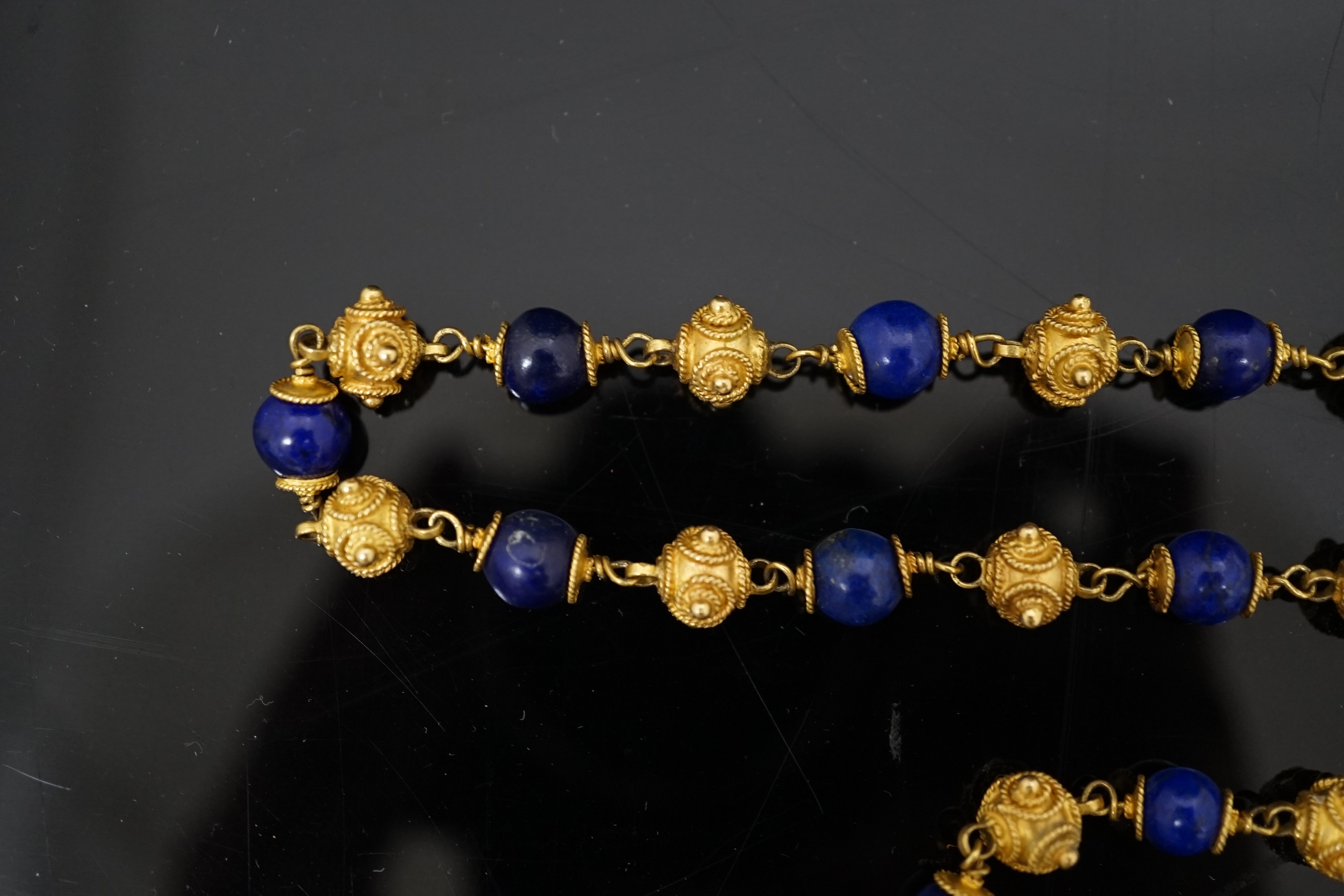 A 20th century Middle Eastern high carat gold canetile work bead and lapis lazuli bead set necklace and matching bracelet